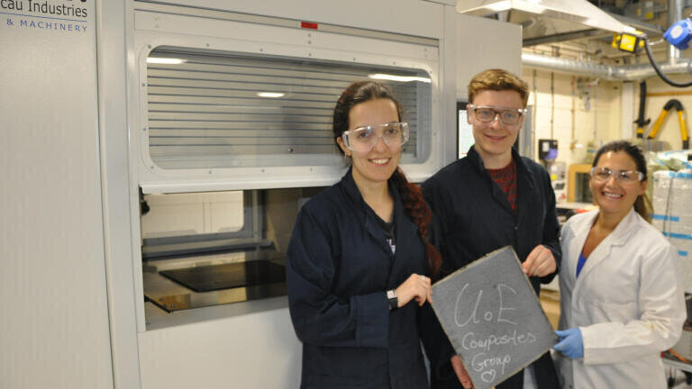 The students from the Composites Group proudly display the first CF/PEEK composite sample produced on the press. From left to right, Helena Pérez Martin, Sean Martin-Beattie and Eva Pappa.